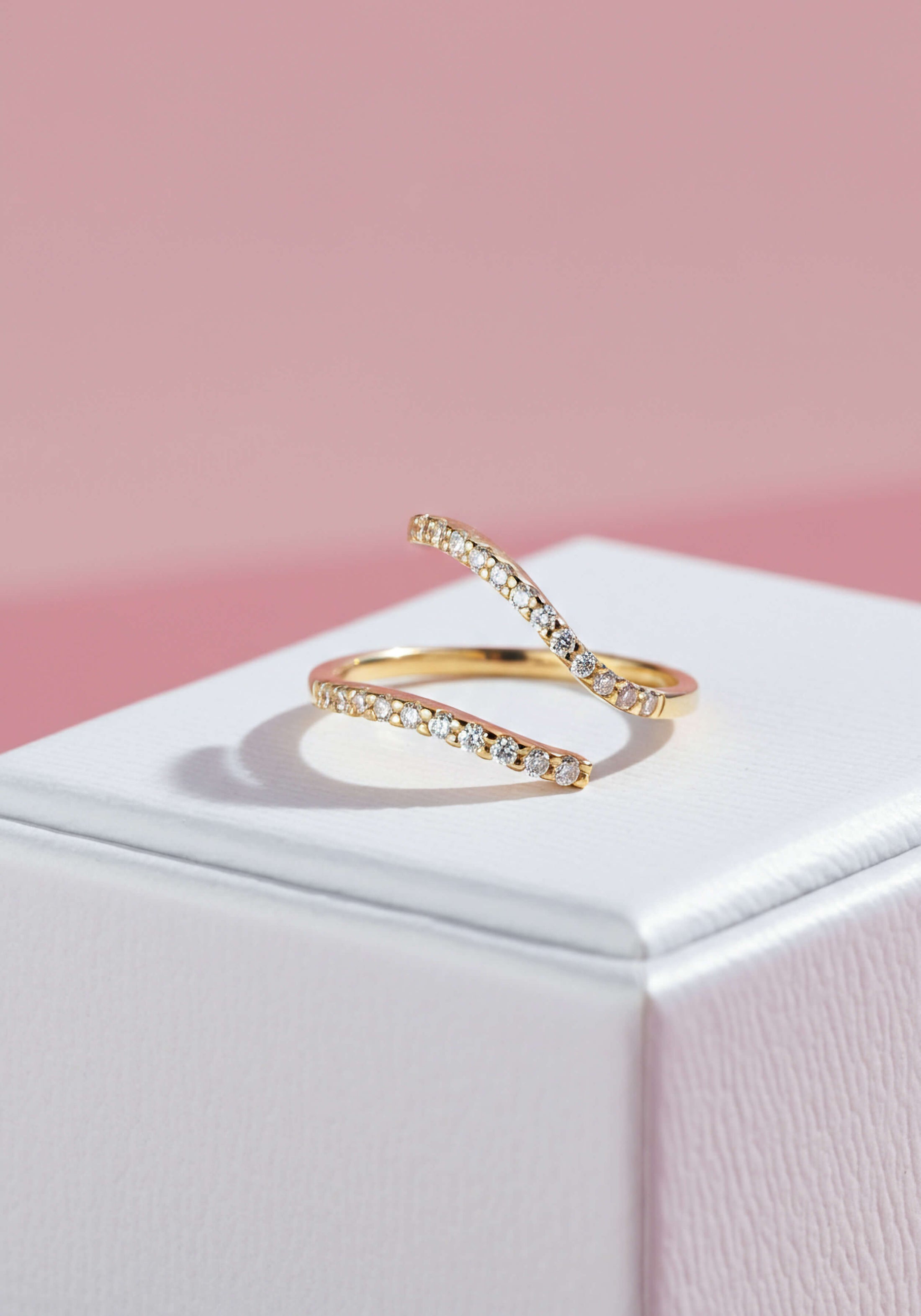 An asymmetric gold ring with a break in the middle encrusted in diamonds.