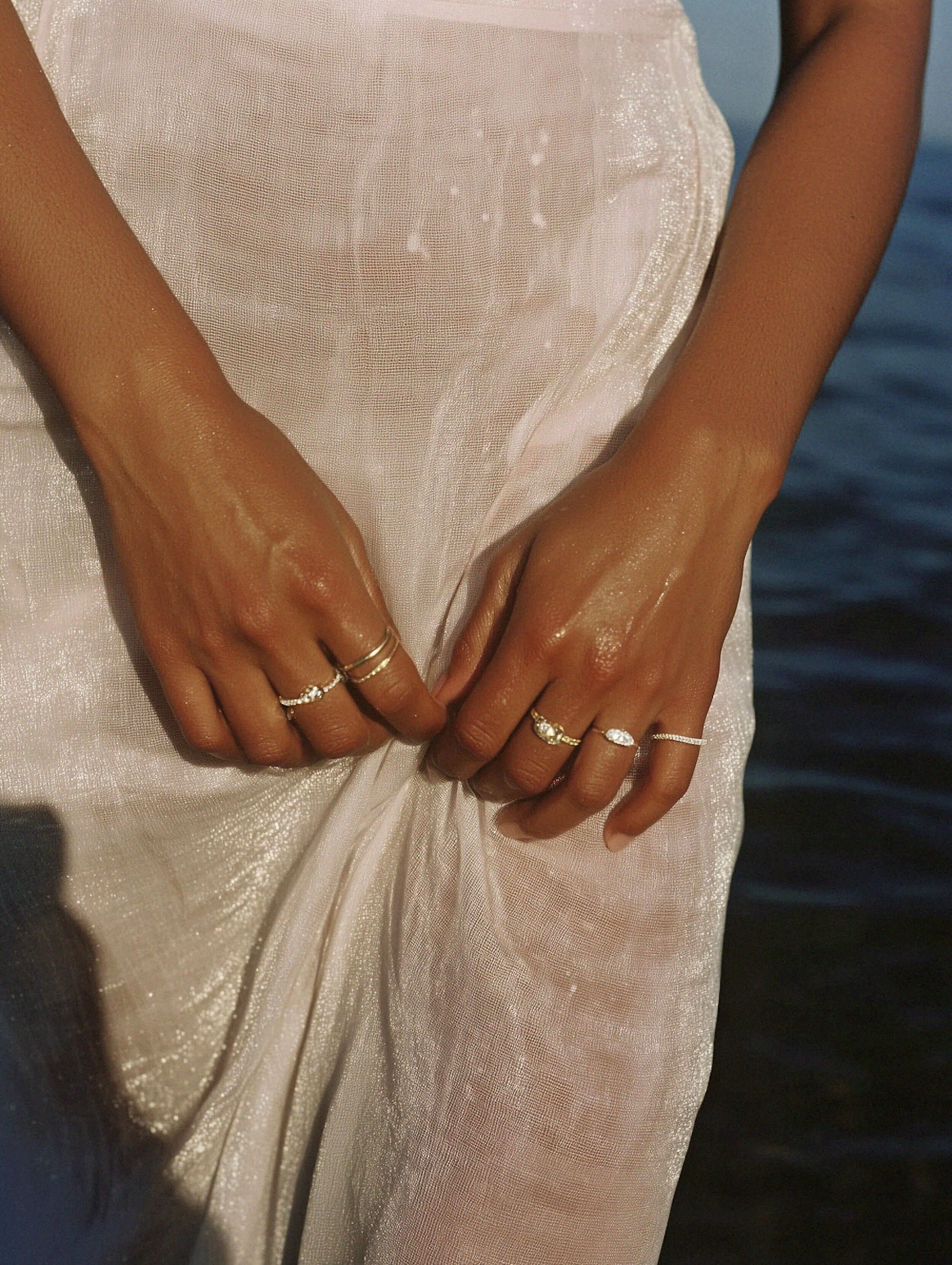 Close up of model's hands wearing various rings.