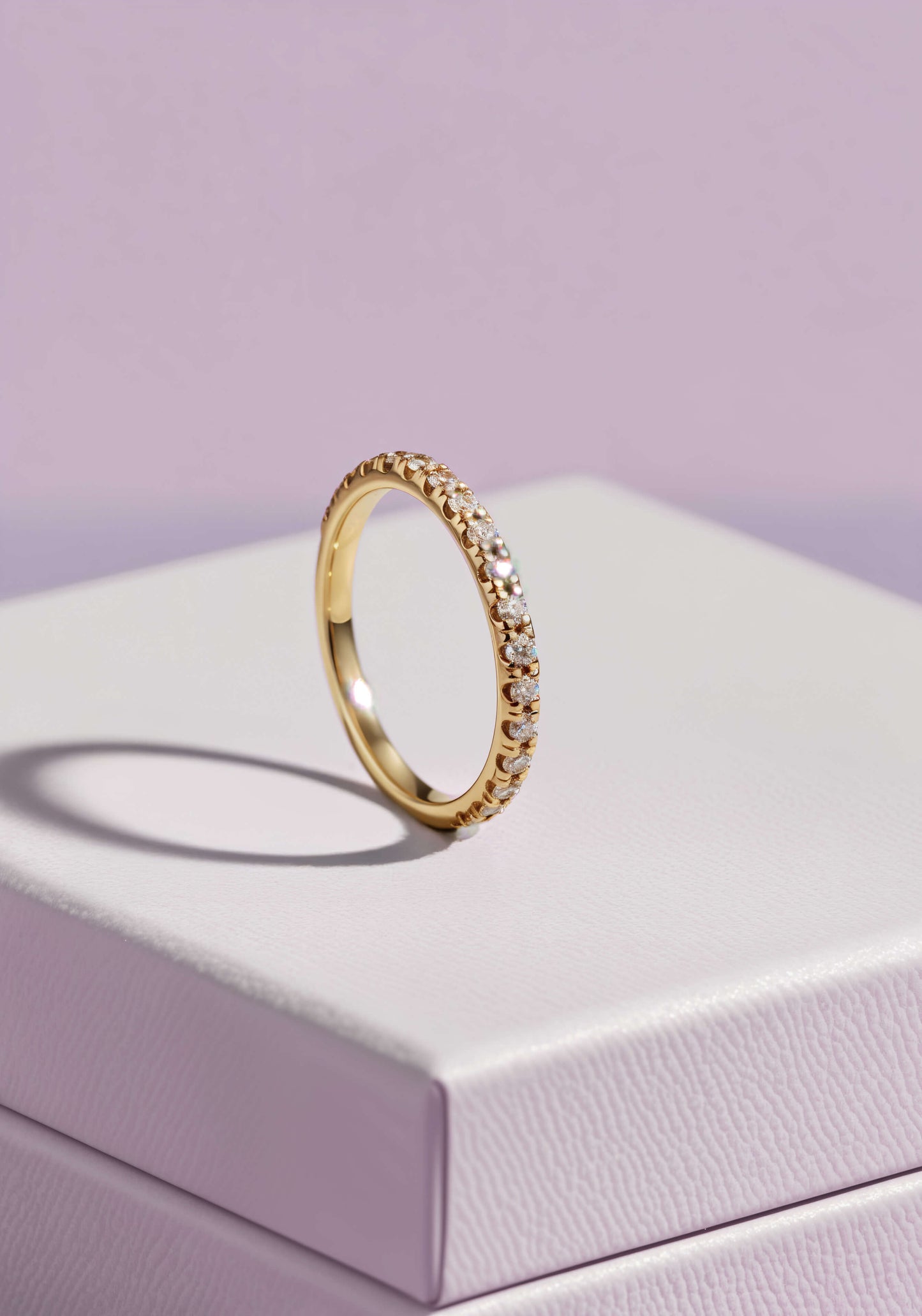 A diamong encrusted gold ring on a white jewelry box.