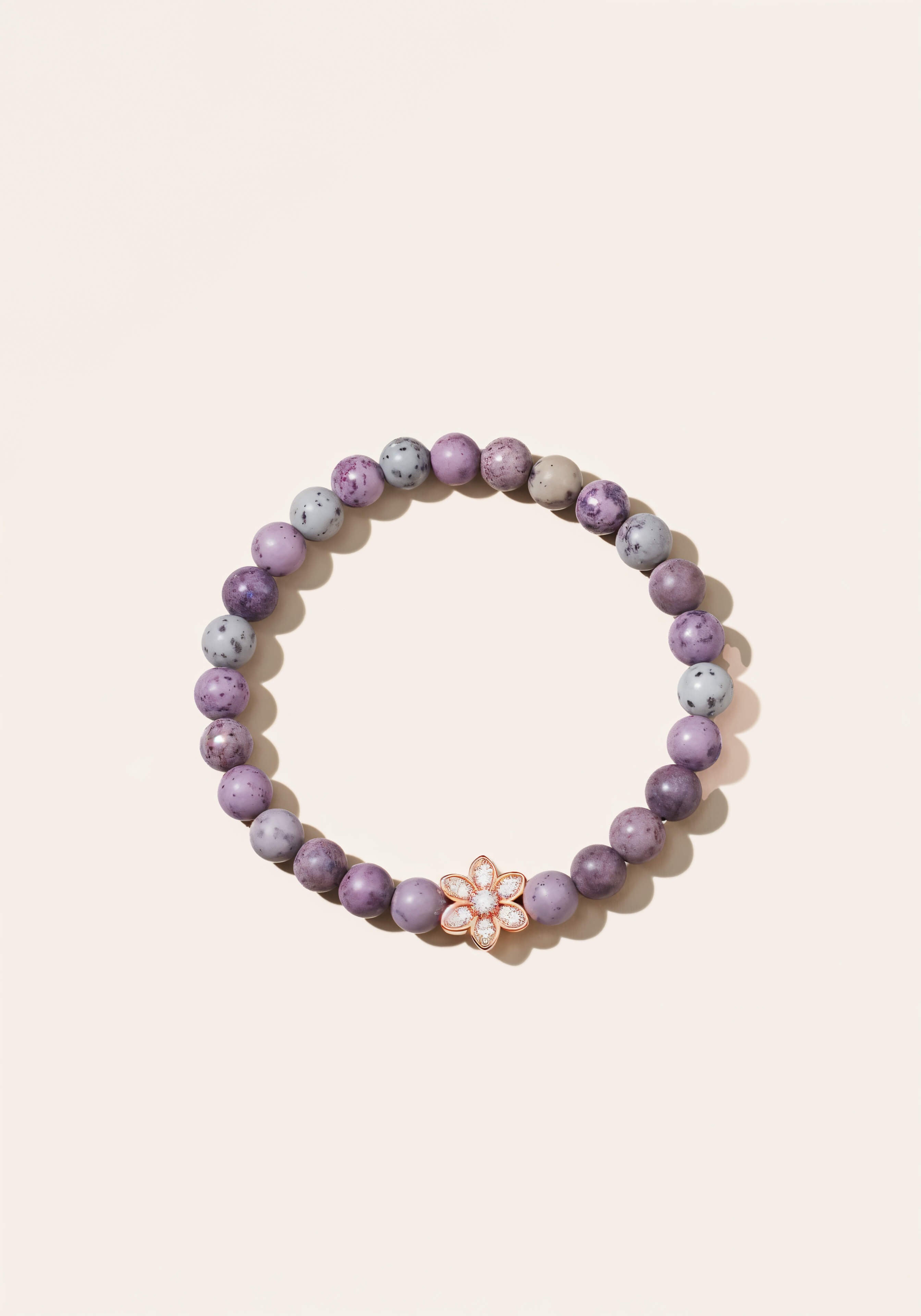 Beaded raw amethyst bracelet with a gold diamond flower in the center