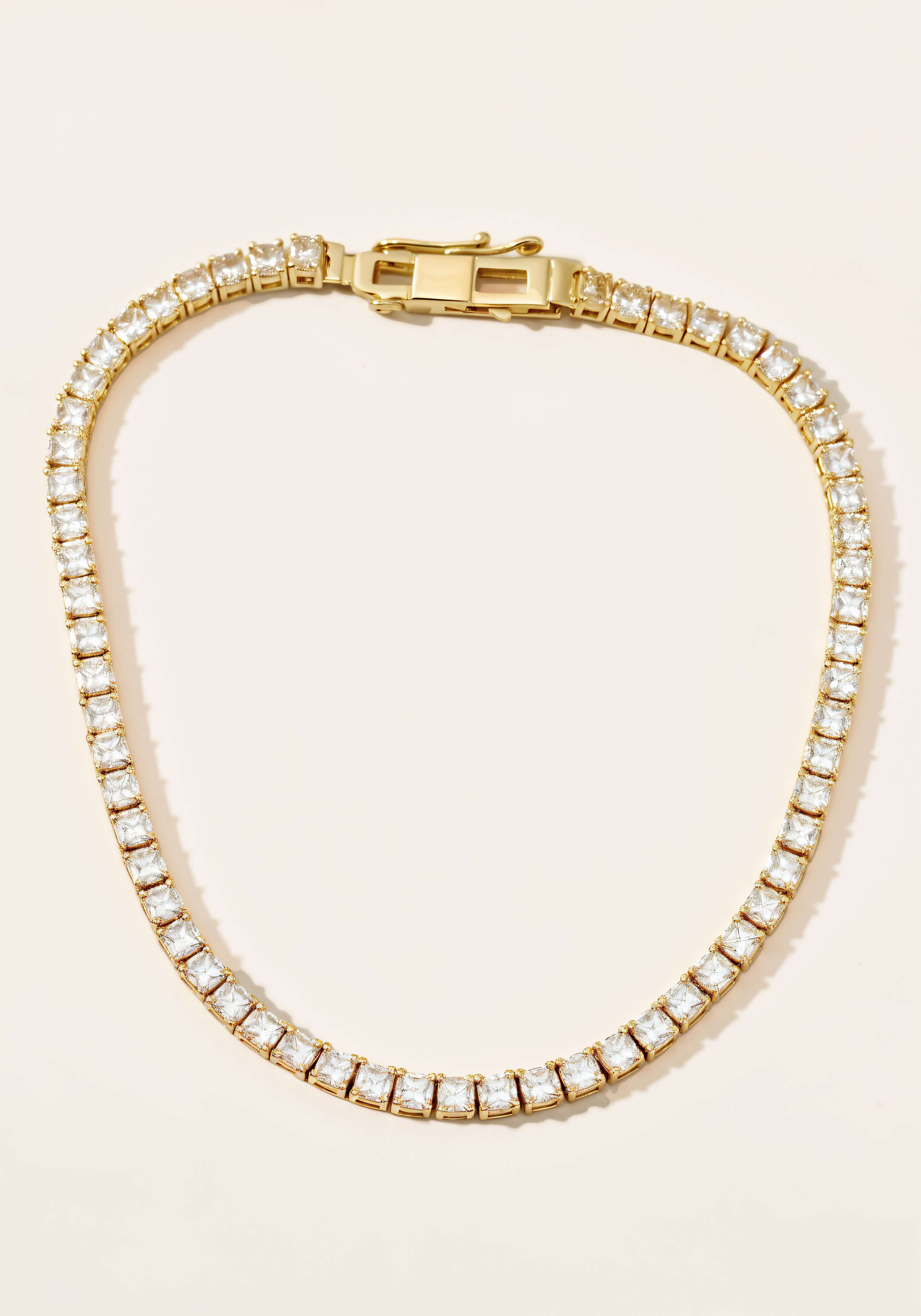 A gold tennis necklace, a continuous strand diamonds set in square links.