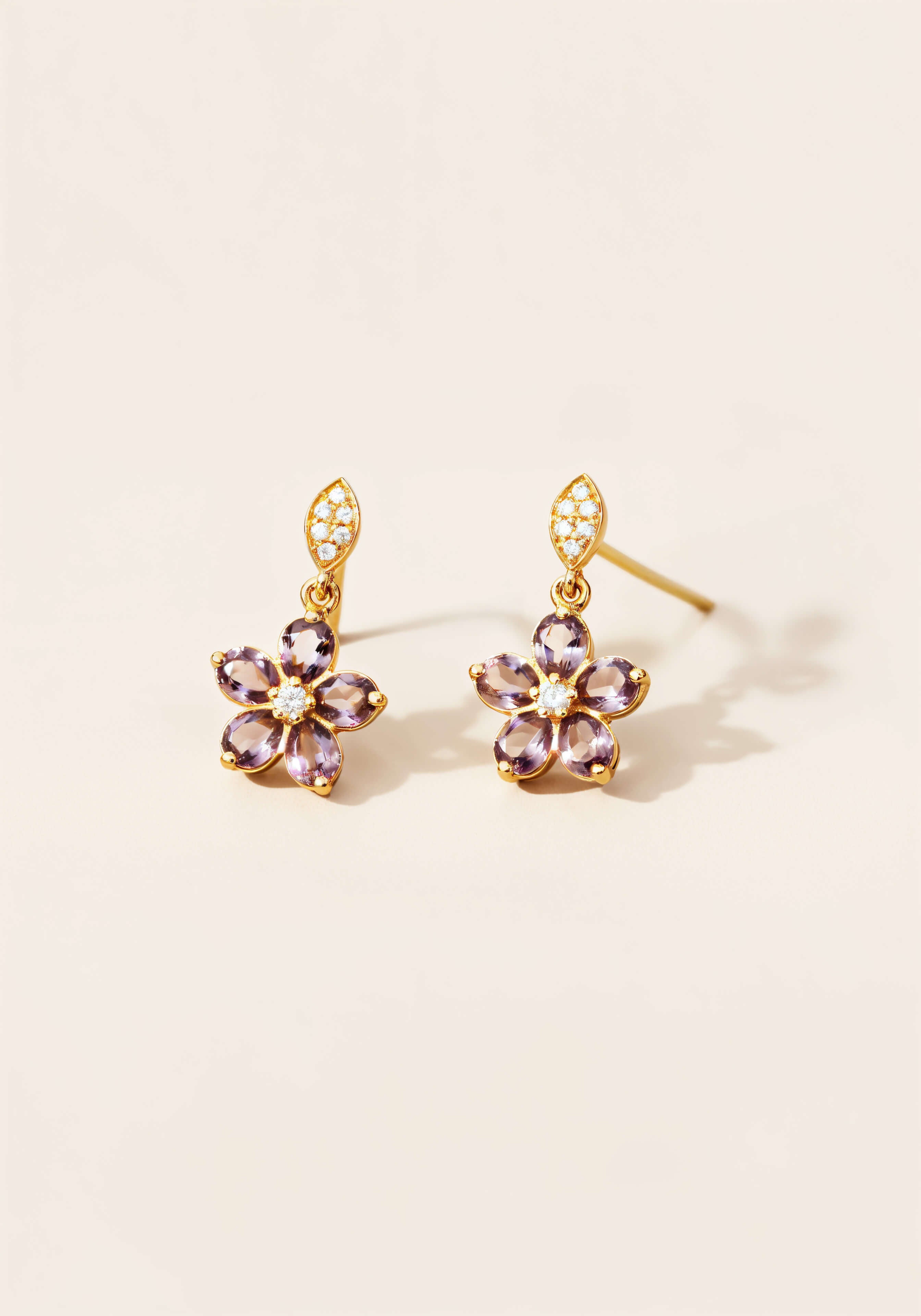 Gold earrings with a five petal amethyst flower dangling from a diamond encrusted marquise set in gold. 